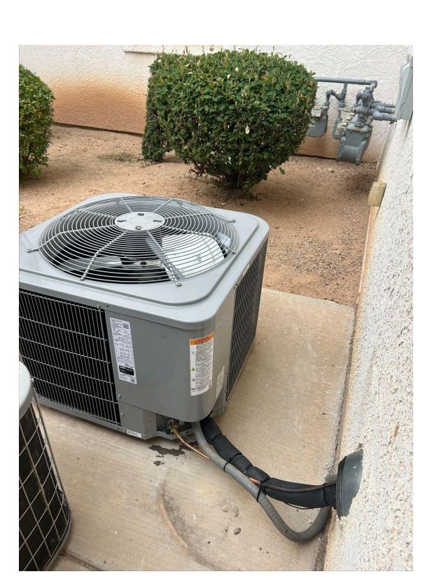 Outdoor air conditioning unit on concrete slab with nearby bushes and gas meter in the background.